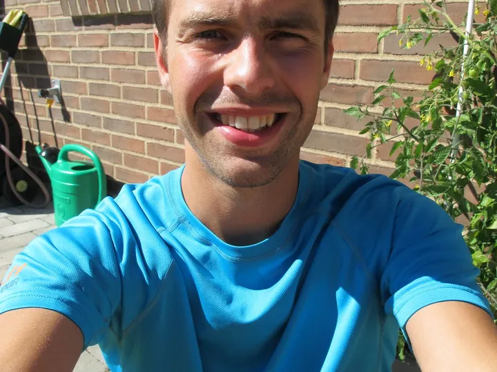 Greg Nowak sitting and smiling in a blue t-shirt.